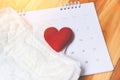 Sanitary napkin or feminine sanitary pad on calendar with red heart - Female hygiene means women Period Product absorbent sheets