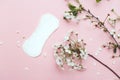 The sanitary napkin lying with blossom on pink background