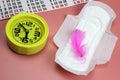 Sanitary pad, pen, calendar, clock on pink. Personal hygiene, the concept of feminine hygiene. Critical days, blood period,