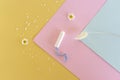 A sanitary tampon lies on a colorful background