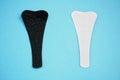 Sanitary white and black napkins for woman, menstrual pads on a blue background. Menstruation cycle. Hygiene and protection