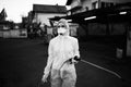 Sanitation service worker spraying disinfectant with a spray gun in hazmat suit,N95 mask and protective gear.Private protective