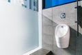 Sanitation white ceramic urinal in the men`s bathroom with hygienic automatic water-saving electronic flusher.