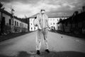 Sanitation worker in hazmat protection suit and N95 mask with chemical decontamination sprayer tank.Disinfecting streets and