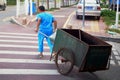 Sanitation workers dragging garbage truck