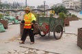 Sanitation workers pull garbage truck