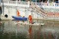 Sanitation workers in the river clean up garbage