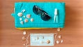 Sanitizer bottle, face mask, sunglasses and shells on a blue towel against a wood background. The concept of a summer Royalty Free Stock Photo