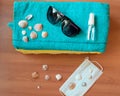 A sanitizer bottle, face mask, sunglasses and shells on a blue towel against a wood background. The concept of a summer Royalty Free Stock Photo