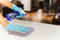 Sanitizing surfaces cleaning kitchen table with disinfectant spray bottle with towel and gloves. COVID-19 prevention.