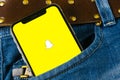 Snapchat application icon on Apple iPhone X smartphone screen close-up in jeans pocket. Snapchat app icon. Social media icon. Royalty Free Stock Photo