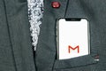 Google Gmail application icon on Apple iPhone X smartphone screen close-up in jacket pocket. Gmail app icon. Gmail is popular Int