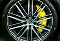 Front view of logo of Porsche on alloy wheel. Car exterior details.