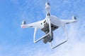 The New Aircraft DJI Phantom 4 pro quadcopter drone with 4K video camera and wireless remote controller flying in the sky. Aerial