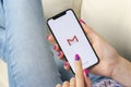 Google Gmail application icon on Apple iPhone X smartphone screen close-up in woman hands. Gmail app icon. Social media icon Royalty Free Stock Photo