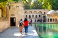 Sanli Urfa, Turkey: September 12 2020: Rear view of two female tourists near Pool of Abraham Balikli Gol and historic buildings