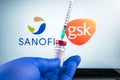 sanofi and gsk logo and covid-19 coronavaccine injection vial, sterile glass with label