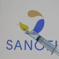 Sanofi sign with a blue syringe for Covid-19 vaccine