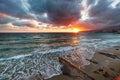 Sanremo, Riviera dei Fiori, Liguria, Italy. Scenis rocks and pebbles on beach illuminated beautiful by sunset light. Dramatic