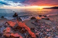 Sanremo, Riviera dei Fiori, Liguria, Italy. Scenis rocks and pebbles on beach illuminated beautiful by sunset light. Dramatic