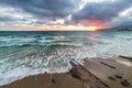 Sanremo, Riviera dei Fiori, Liguria, Italy. Scenis rocks and pebbles on beach illuminated beautiful by sunset light. Dramatic