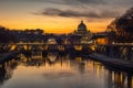 The Sant Angel Bridge and Vatican City silhouette during a colorful sunset reflected in the Tiber River, Rome, Italy Royalty Free Stock Photo