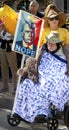 Elderly Man in a Wheelchair Holds an Anti-Trump Sign