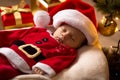 Santa baby sleeping with Christmas presents at living room Royalty Free Stock Photo