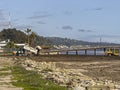 Dump truck deliever to Bulldozer to put dirt over beach into ocean at Goleta pier, CA, USA Royalty Free Stock Photo