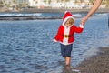 Santa boy at sand beach water Royalty Free Stock Photo