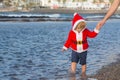 Santa boy at sand beach water Royalty Free Stock Photo