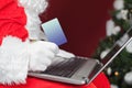 Santa buying by plastic card Christmas gift in Internet Royalty Free Stock Photo