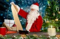 Santa checks the wish list for the gifts in his workshop Royalty Free Stock Photo