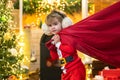 Santa child. Santa helper holding a red bag with presents. Merry christmas and happy new year. Surprised Little Santa in Royalty Free Stock Photo