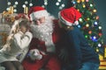 Santa and children around the decorated Christmas tree. Wishes list Royalty Free Stock Photo