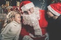 Santa and children around the decorated Christmas tree. Wishes list Royalty Free Stock Photo