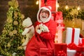 Santa with Christmas gift. Funny Santa. Santa grandfather with a white beard posing on the Christmas wooden background