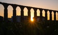 Santa Clara Aqueduct, Vila do Conde, Portugal at sunset with sun shining through arches