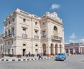 Building of Caridad Theater in Vidal Park. Blue retro moving along street of city Santa Clara, Cuba