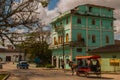 SANTA CLARA, CUBA: The usual street in the city. Green multi-storey building. Horse-drawn carriage. Horse cart to transport people