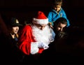 A Santa Claus, also known as Father Christmas gives sweets to children