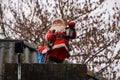 Santa Claus as a Christmas decoration on a chimney, Holidays winter time. tradition with presents and conviviality.