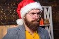 Santa claus attributes concept. Man bearded mature guy serious face wear santa hat with fur and old fashioned eyeglasses