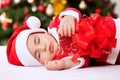 Santa claus baby sleeping and holding present Royalty Free Stock Photo