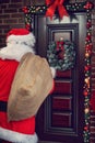 Santa Claus with big sack in front of home, back view Royalty Free Stock Photo