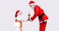Santa Claus with a black belt is giving little girl in karategi Cup of Karate