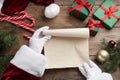 Santa Claus with blank paper and Christmas decor at wooden table, top view Royalty Free Stock Photo