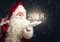 Santa Claus blowing magic snow of his hand, holding a year 2018 Royalty Free Stock Photo