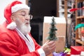 Santa Claus blowing snow at tiny christmas tree Royalty Free Stock Photo