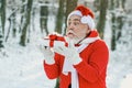 Santa Claus blows snow. Happy Santa blowing on snow. Portrait of happy Santa Claus walking in snowy forest and Blowing Royalty Free Stock Photo